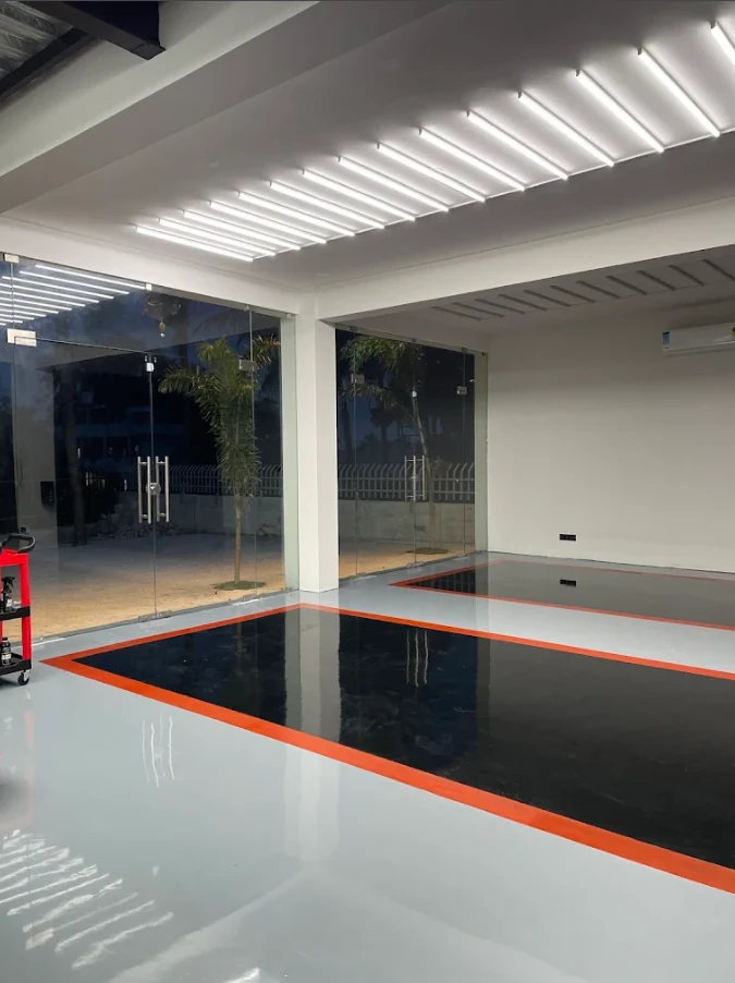 Detailing bay with bright overhead lighting and marked work areas