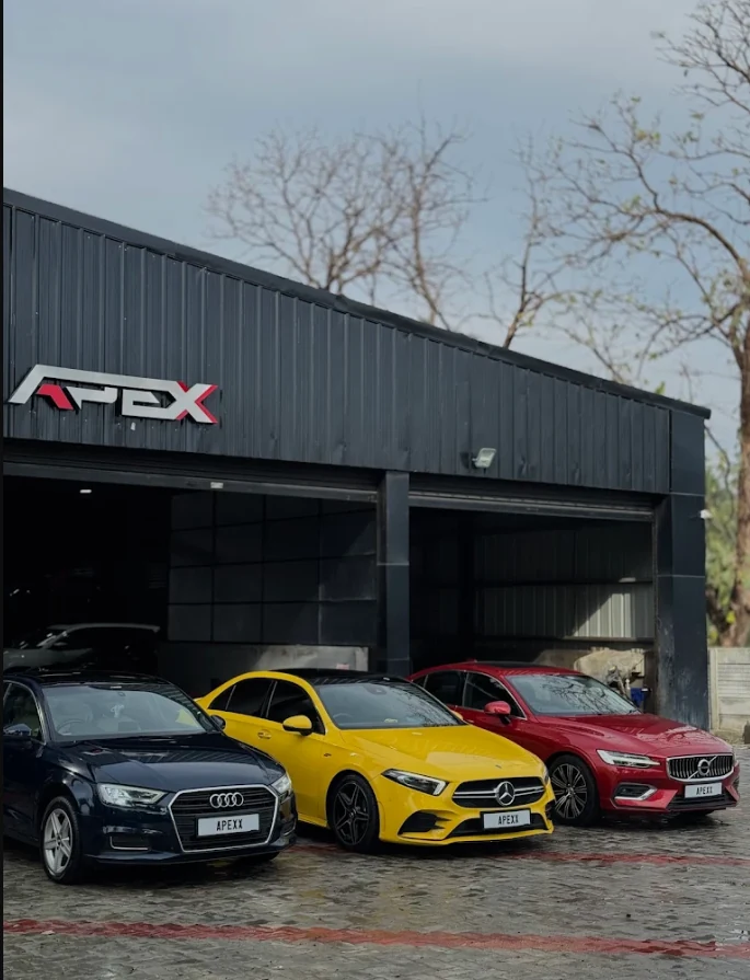 Workshop entrance with vehicles parked beneath the industrial canopy
