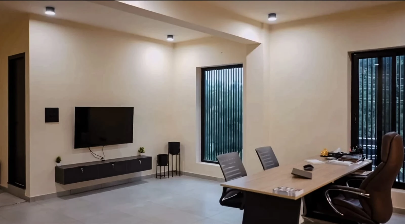 Completed meeting room with a timber table and wall-mounted screen
